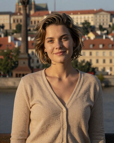 Tereza 28 from Prague in camel cardigan on a bridge at sunset